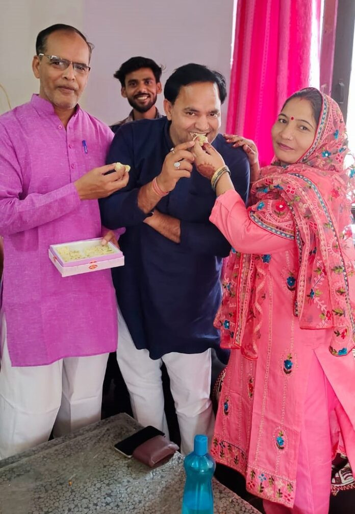 Feeding sweets to independent candidate Vikas Dayal